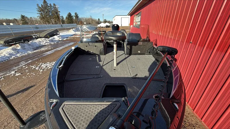 Slide: The Image of 2024 Nitro ZV20 boat parked beside a red building on a snowy day. - 2
