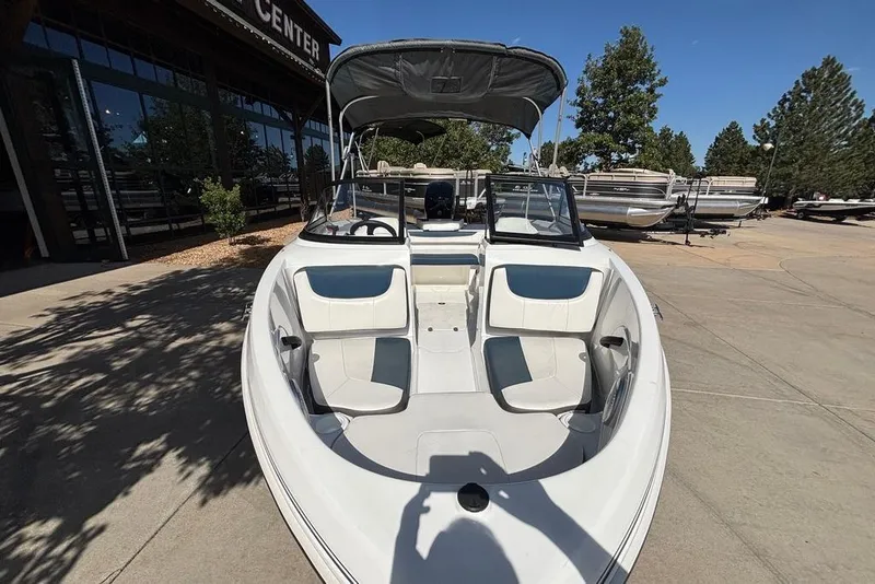 Slide: The Image of 2024 Tahoe 185 S boat with seating, parked outdoors near a showroom. - 2