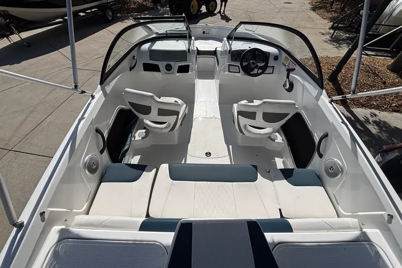 Slide: The Image of 2024 Tahoe 185 S boat interior with seating and steering wheel, docked outdoors. - 3
