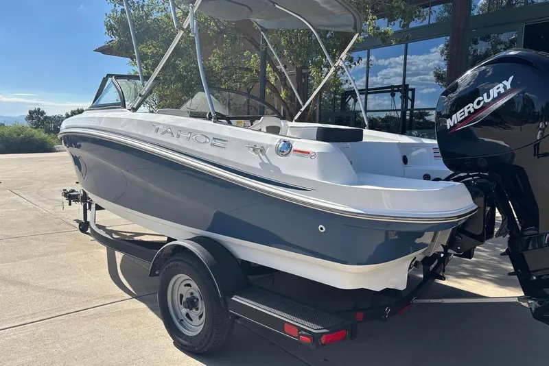 Slide: The Image of 2024 Tahoe 185 S boat with Mercury engine on trailer, parked outdoors. - 11