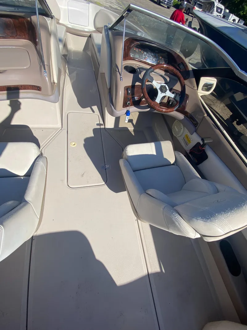 Slide: The Image of 2002 Regal 1900 LSR boat interior with white seating and wood-accented steering wheel. - 11