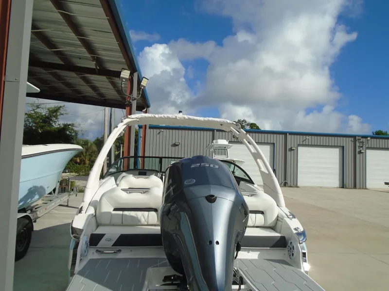 Slide: The Image of 2025 Regal LX2 boat with powerful outboard motor, parked outdoors under blue sky. - 11