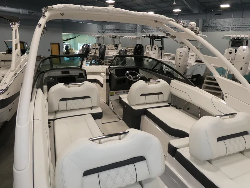 Slide: The Image of 2025 Regal LX2 boat interior with luxurious white seating in showroom. - 24
