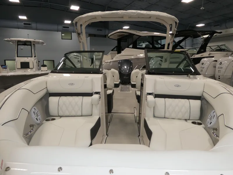 Slide: The Image of 2025 Regal LX2 boat interior with luxurious seating in a showroom. - 25