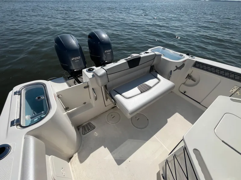 Slide: The Image of 2019 Wellcraft 262 Fisherman boat with dual engines, spacious seating, and ocean backdrop. - 10