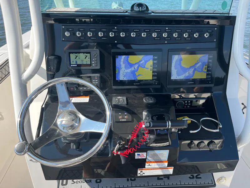 Slide: The Image of Control panel of 2019 Wellcraft 262 Fisherman boat with navigation screens and steering wheel. - 17