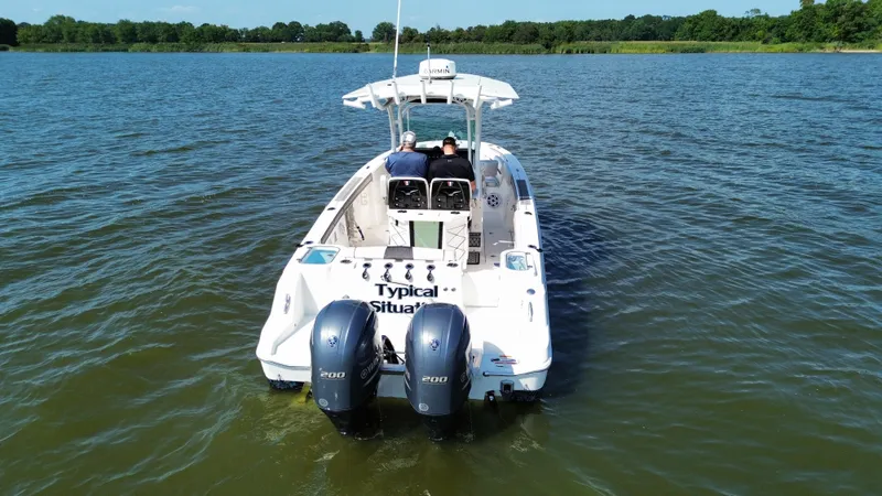 Slide: The Image of 2019 Wellcraft 262 Fisherman boat on a lake with dual outboard motors. - 2