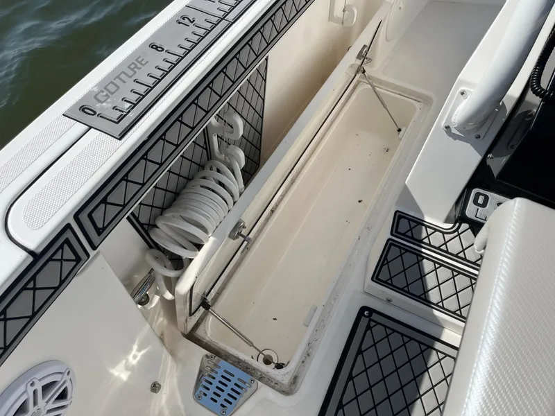 Slide: The Image of 2019 Wellcraft 262 Fisherman boat interior with storage compartment and coiled hose. - 28