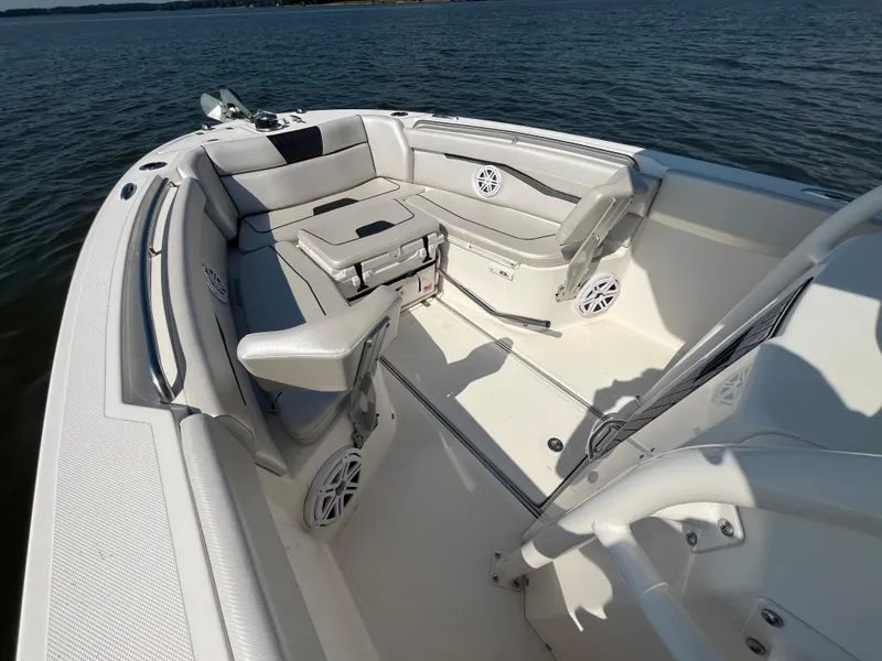 Slide: The Image of 2019 Wellcraft 262 Fisherman boat interior with seating and speakers on calm water. - 29