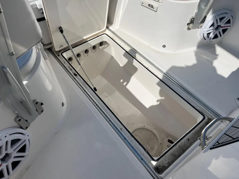 Slide: The Image of 2019 Wellcraft 262 Fisherman boat storage compartment, open and empty, with visible speakers. - 32