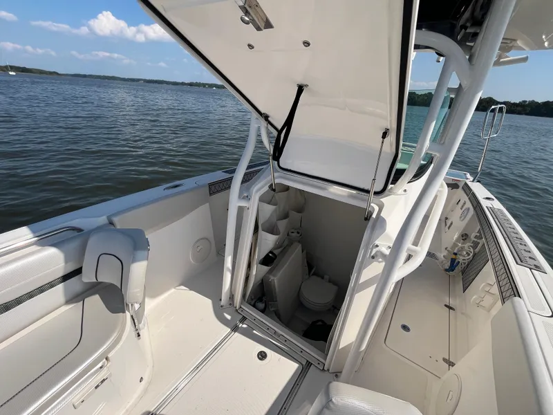 Slide: The Image of 2019 Wellcraft 262 Fisherman boat interior with open hatch, revealing compact cabin space. - 34