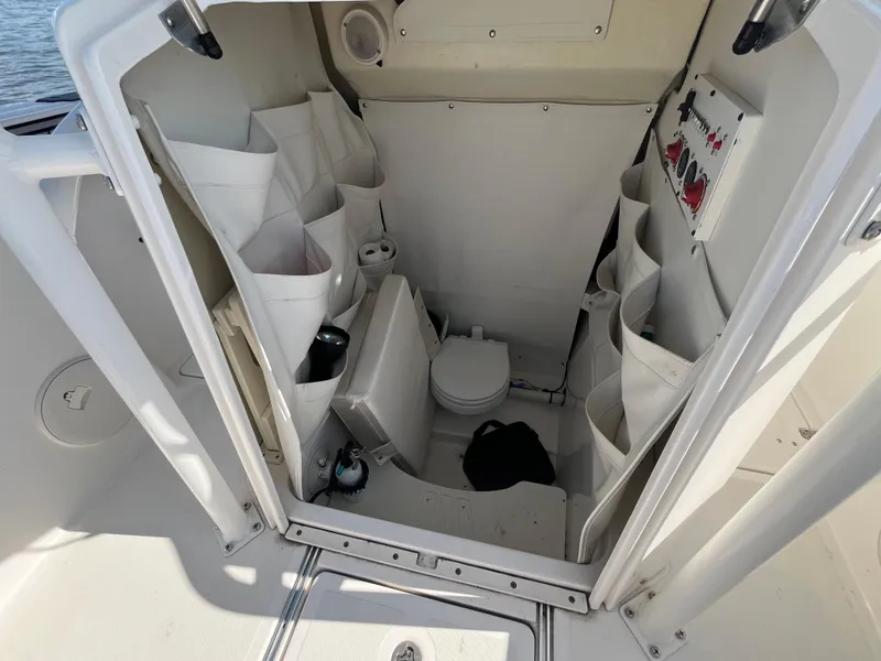 Slide: The Image of 2019 Wellcraft 262 Fisherman boat interior with storage compartments and marine toilet. - 35