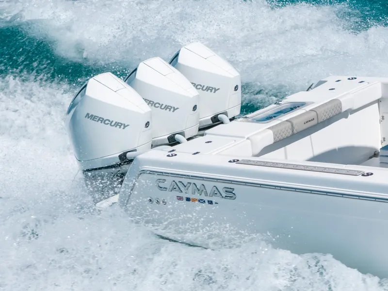 Slide: The Image of 2023 Caymas 341 CC boat with triple Mercury engines navigating through waves. - 1