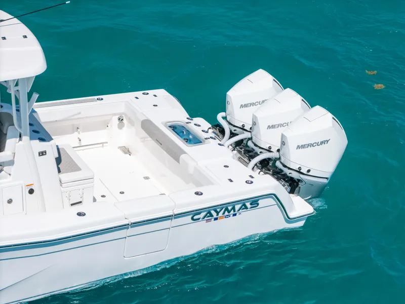 Slide: The Image of 2023 Caymas 341 CC boat with triple Mercury engines on turquoise water. - 11
