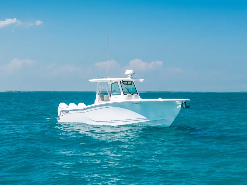 Slide: The Image of 2023 Caymas 341 CC boat on clear blue ocean water under a sunny sky. - 23