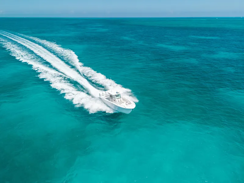 Slide: The Image of 2023 Caymas 341 CC boat cruising on clear turquoise ocean waters. - 28