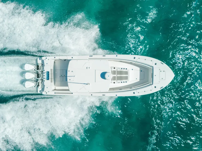 Slide: The Image of 2023 Caymas 341 CC boat cruising on turquoise water, aerial view. - 29