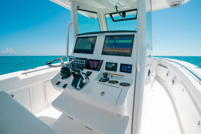 Slide: The Image of 2023 Caymas 341 CC boat dashboard with modern controls and ocean view. - 3