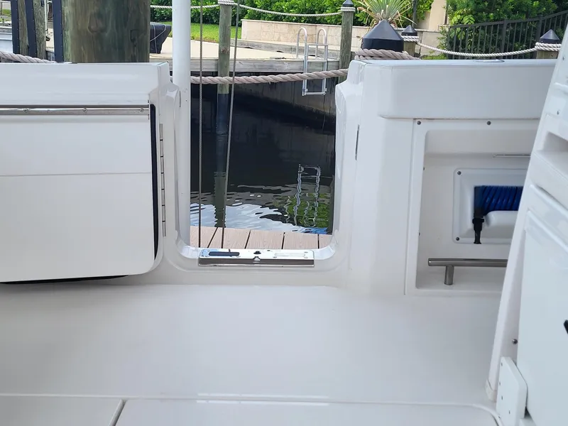 Slide: The Image of 2023 Caymas 341 CC boat interior, featuring sleek white design and dockside view. - 33