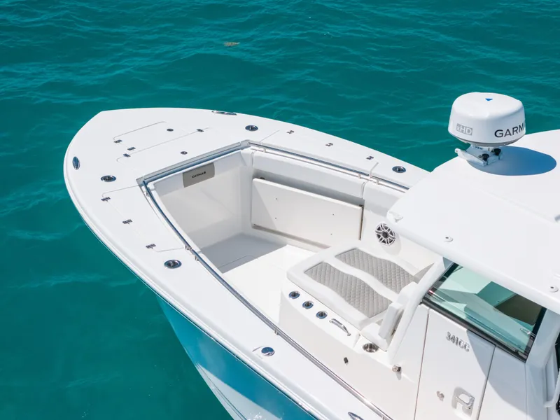 Slide: The Image of 2023 Caymas 341 CC boat on turquoise water, featuring a sleek white deck design. - 5