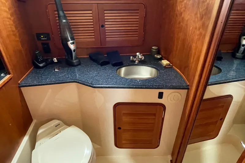 Slide: The Image of 2007 Hinckley Talaria 44 Flybridge bathroom with sink, toilet, and wooden cabinetry. - 12