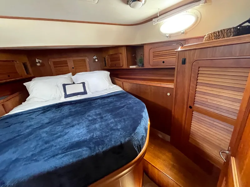 Slide: The Image of Luxurious cabin interior of 2007 Hinckley Talaria 44 Flybridge with wood finish and cozy bedding. - 13