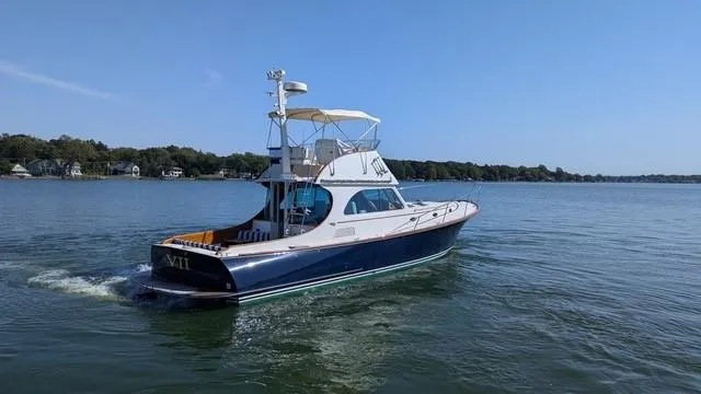 Slide: The Image of 2007 Hinckley Talaria 44 Flybridge yacht cruising on a calm lake. - 16