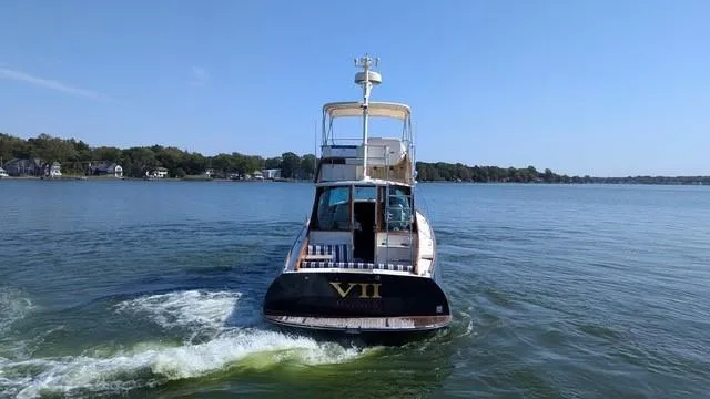 Slide: The Image of 2007 Hinckley Talaria 44 Flybridge cruising on a calm lake under a clear blue sky. - 2