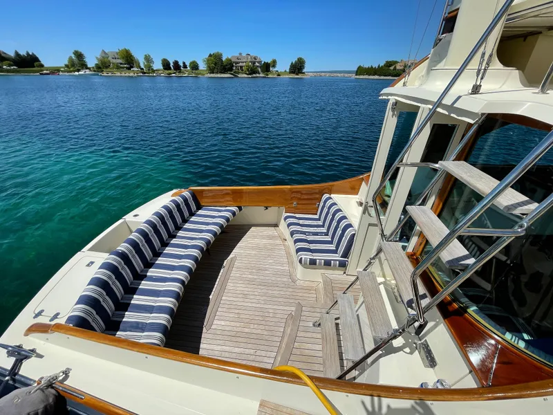 Slide: The Image of 2007 Hinckley Talaria 44 Flybridge yacht with striped seating, docked on a sunny day. - 3