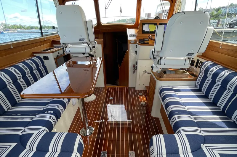 Slide: The Image of Interior of 2007 Hinckley Talaria 44 Flybridge with striped seating and wooden flooring. - 6
