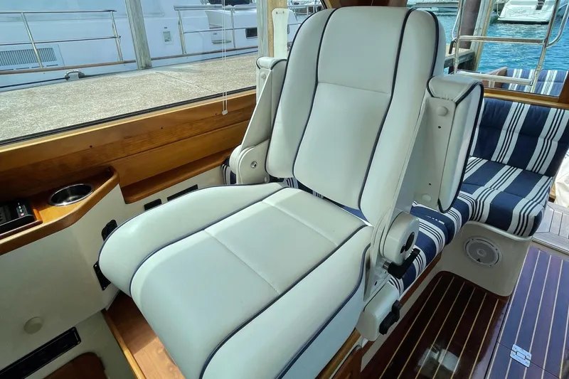 Slide: The Image of Luxurious seating on 2007 Hinckley Talaria 44 Flybridge yacht with striped cushions and wooden accents. - 8