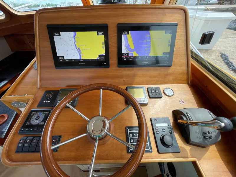Slide: The Image of Helm of 2007 Hinckley Talaria 44 Flybridge with dual navigation screens and wooden steering wheel. - 9