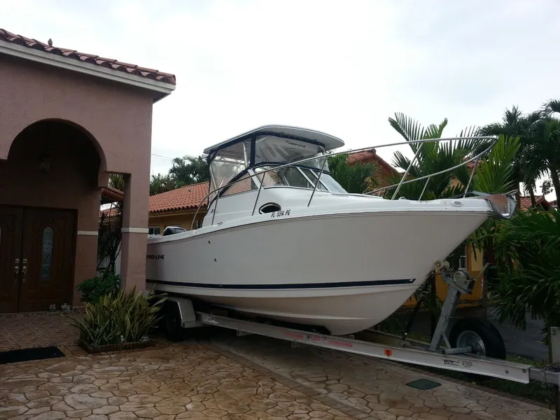 Slide: The Image of 2011 Pro-Line 23 Express boat on trailer beside a house. - 1