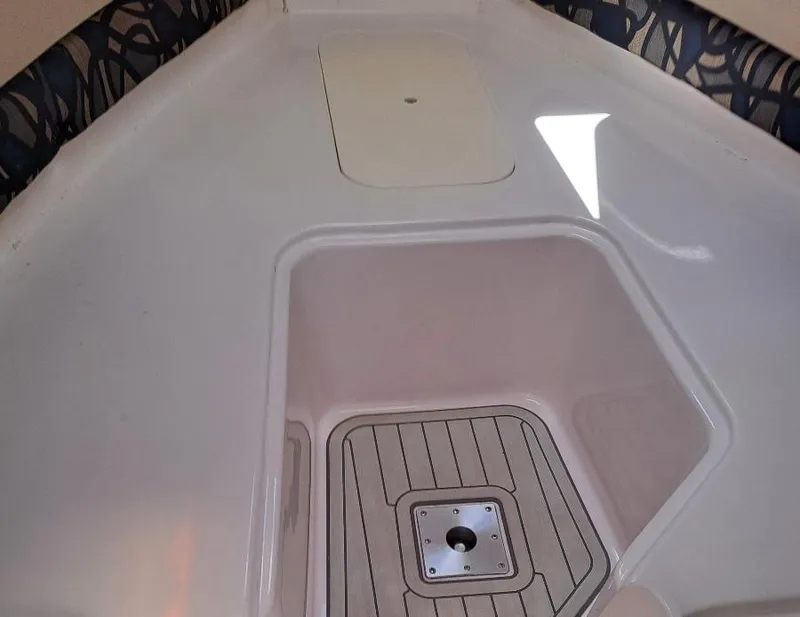 Slide: The Image of 2011 Pro-Line 23 Express boat interior with storage compartment and cushioned seating. - 11