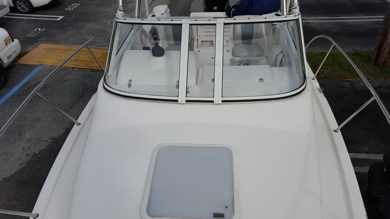 Slide: The Image of 2011 Pro-Line 23 Express boat, white exterior, docked in a parking area. - 13