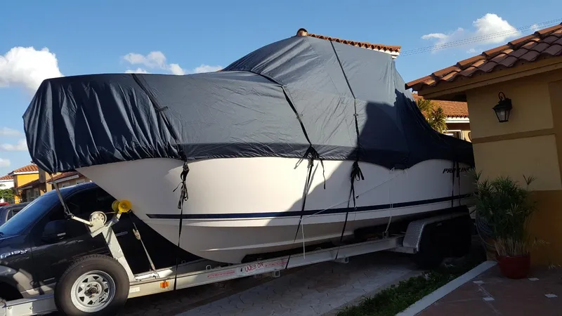 Slide: The Image of 2011 Pro-Line 23 Express boat covered on trailer, parked in driveway. - 14