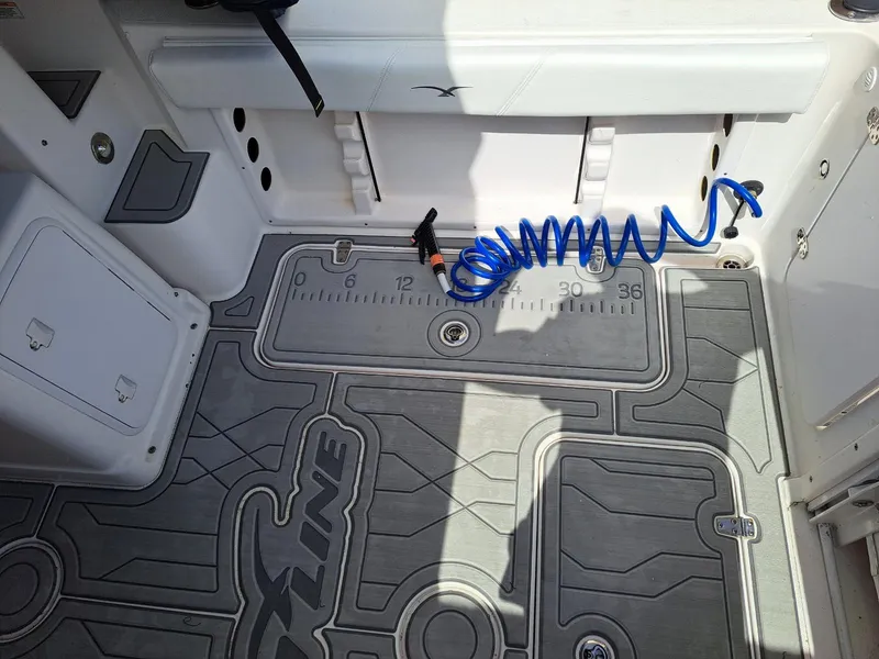Slide: The Image of 2011 Pro-Line 23 Express boat deck with custom flooring and coiled blue hose. - 6