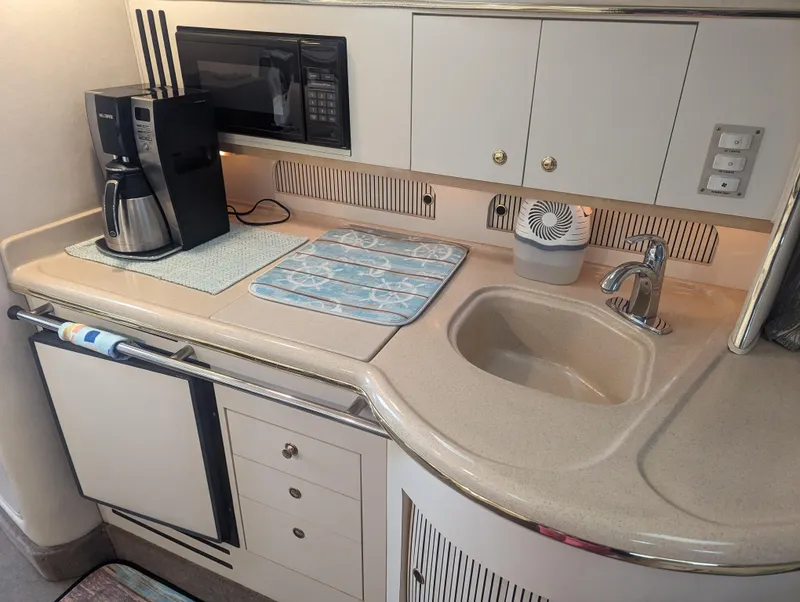 Slide: The Image of 2000 Sea Ray 310 Sundancer galley with sink, coffee maker, and microwave. - 11
