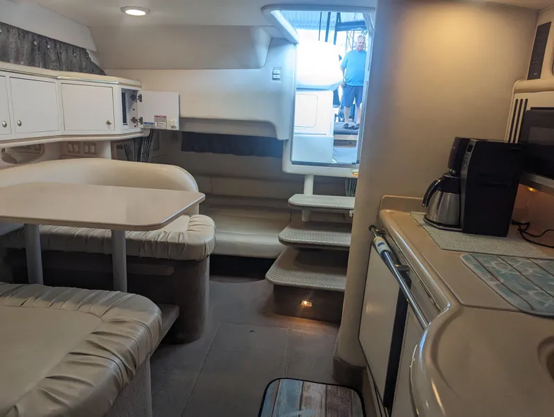 Slide: The Image of Interior of 2000 Sea Ray 310 Sundancer boat with dining area and kitchenette. - 13