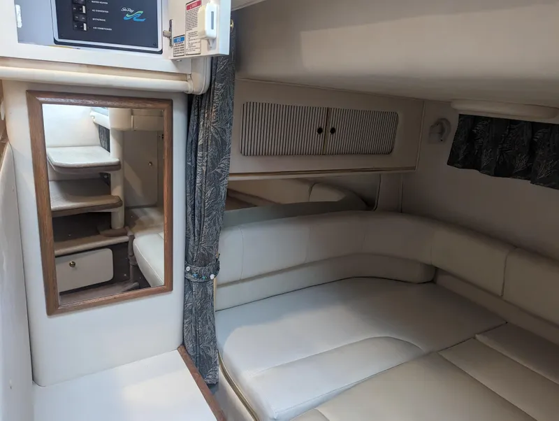 Slide: The Image of Interior cabin of 2000 Sea Ray 310 Sundancer with beige seating and wood accents. - 14
