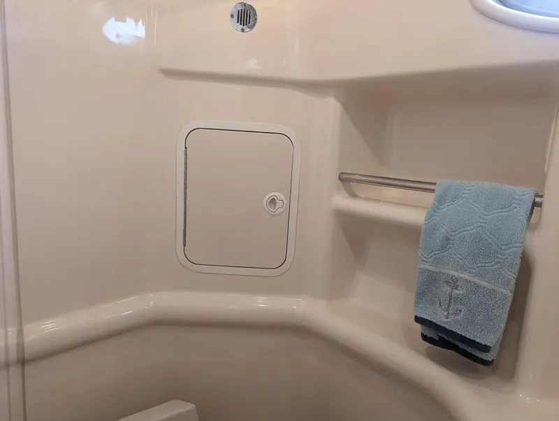 Slide: The Image of Interior of 2000 Sea Ray 310 Sundancer boat bathroom with towel and storage compartment. - 20