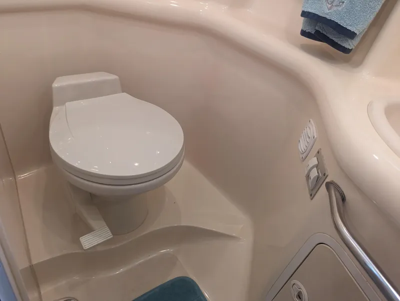 Slide: The Image of Bathroom interior of 2000 Sea Ray 310 Sundancer yacht, featuring a compact toilet. - 21