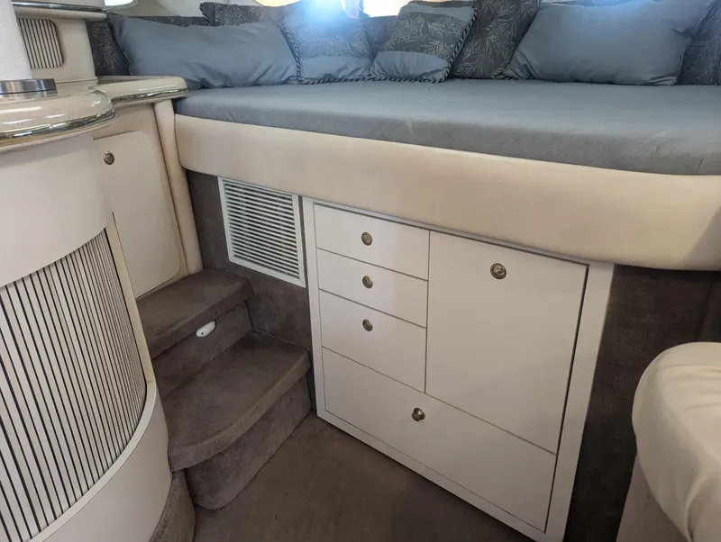 Slide: The Image of Interior of 2000 Sea Ray 310 Sundancer with bed, storage drawers, and steps. - 22