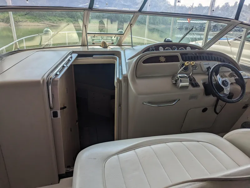 Slide: The Image of 2000 Sea Ray 310 Sundancer helm with steering wheel and cabin entrance. - 24