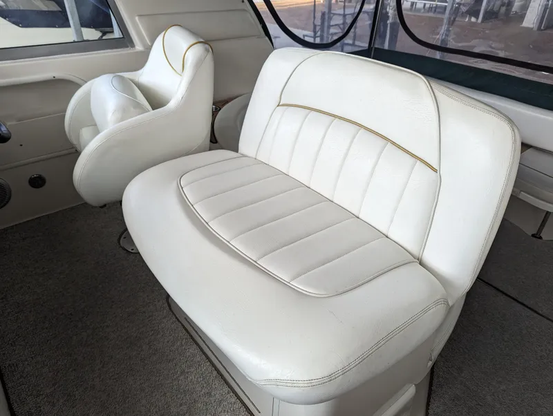 Slide: The Image of Interior seating of 2000 Sea Ray 310 Sundancer boat, featuring white leather upholstery. - 27