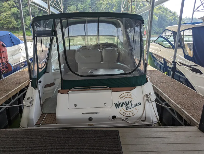 Slide: The Image of 2000 Sea Ray 310 Sundancer docked, rear view with green canopy and "Whiskey Business" nameplate. - 32