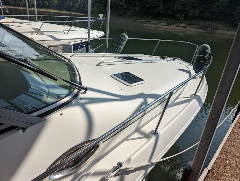 Slide: The Image of 2000 Sea Ray 310 Sundancer docked at a marina, showcasing sleek design and spacious deck. - 35