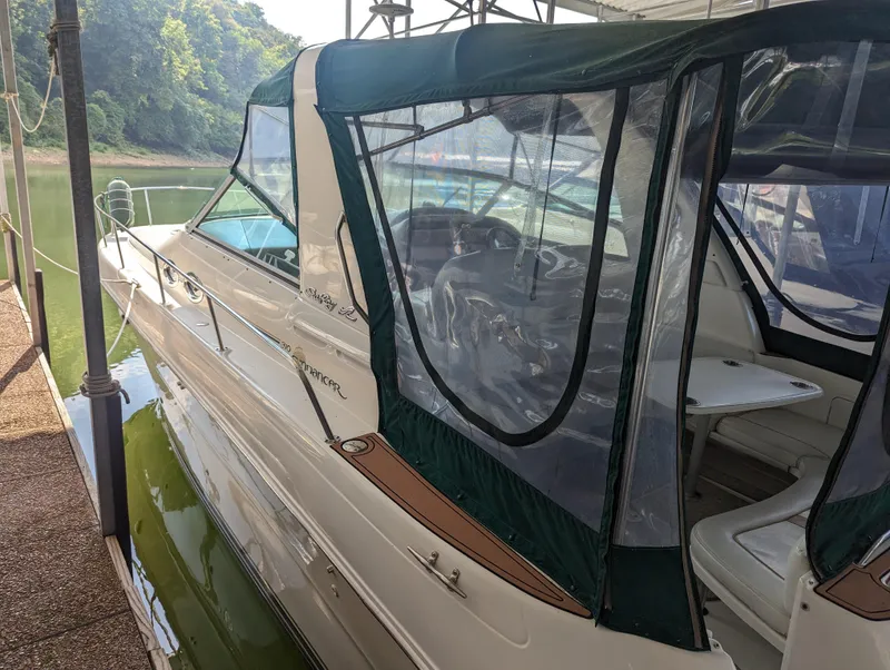 Slide: The Image of 2000 Sea Ray 310 Sundancer boat docked with green canopy and clear windows. - 39