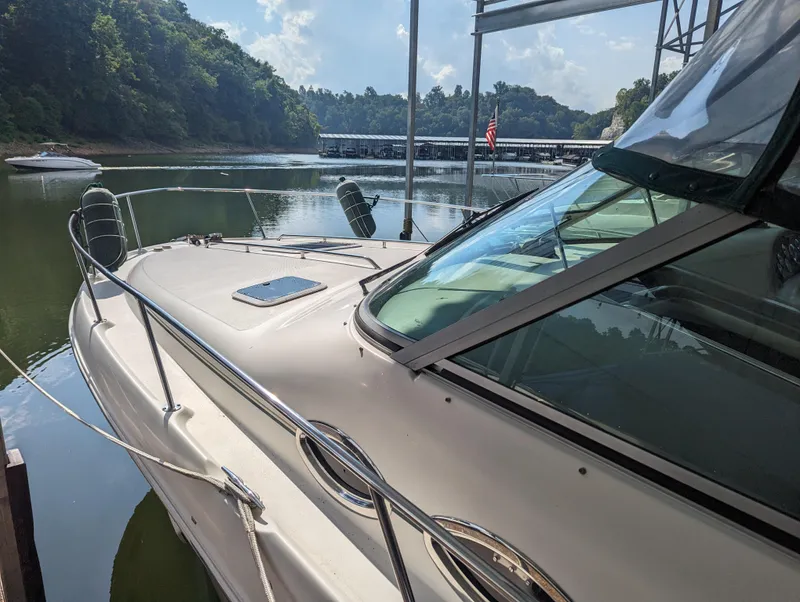 Slide: The Image of Sea Ray 310 Sundancer 2000 docked on a serene lake with lush greenery. - 40