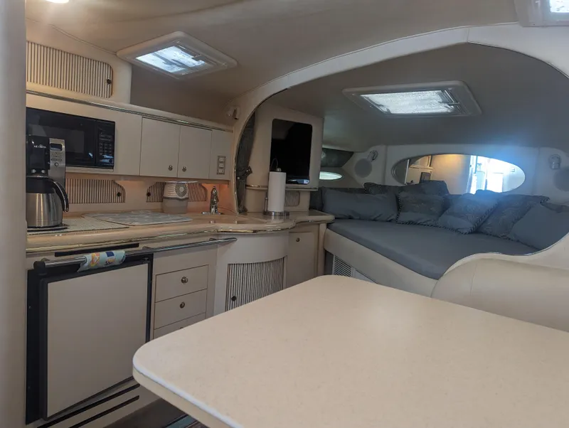Slide: The Image of Interior of 2000 Sea Ray 310 Sundancer yacht with kitchenette and seating area. - 6